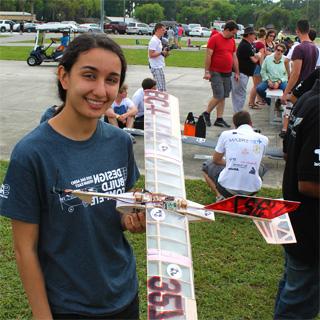 Student holding her self-made plane