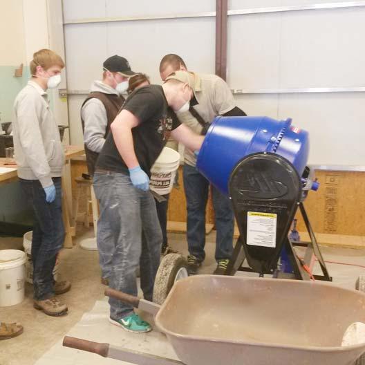 Engineering students mix concrete for a canoe project