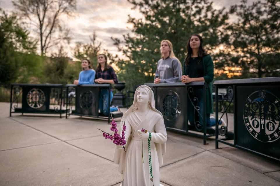 Students pray at Mary's Grotto